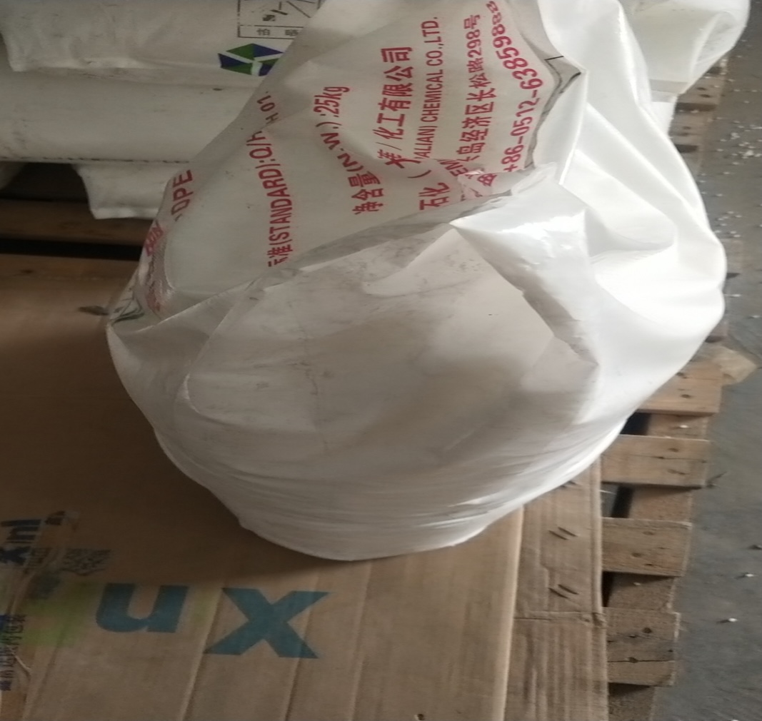 Partial-shot-of-crumpled-Hengli-HDPE-plastic-raw-material-sack-placed-on-wooden-pallet
